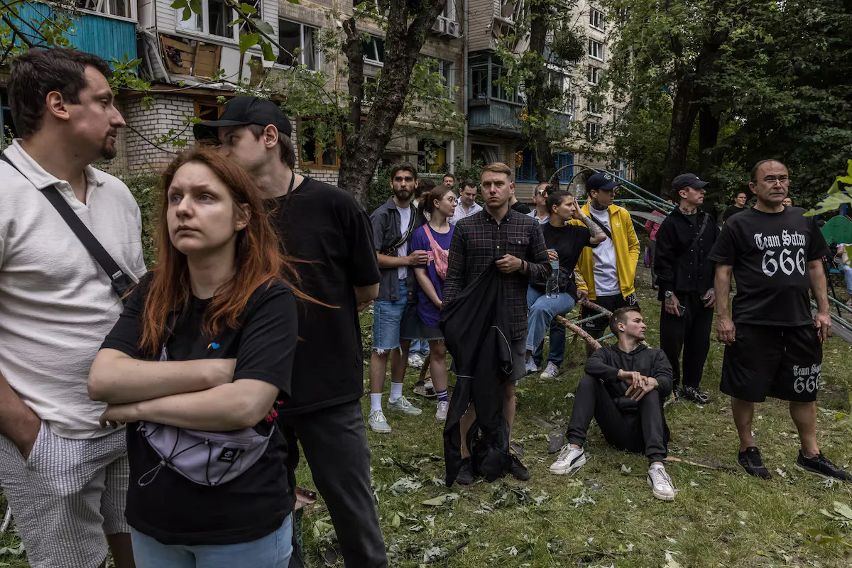 Люди спостерігають за рятувальними роботами поблизу місця російського ракетного удару по житловому будинку в Києві цього місяця.